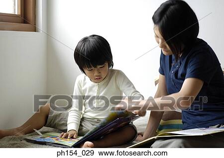 Stock Photo - Mid adult woman teaching her daughter. Fotosearch