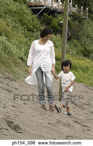 Stock Photo - Mid adult woman walking with her son. Fotosearch