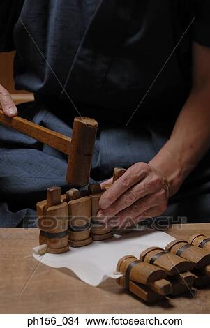 Picture - Mid section view of a carpenter hitting wood with a mallet. Fotosearch