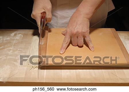 Mid section view of a chef cutting noodles on a cutting board View Large Photo Image Stock Image - Mid section view of a chef cutting noodles on a cutting board. Fotosearch