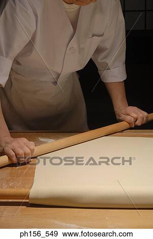 Stock Photo - Mid section view of a chef rolling dough. Fotosearch