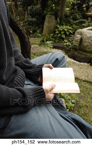 Mid section view of a man holding a book View Large Photo Image Stock Image - Mid section view of a man holding a book. Fotosearch