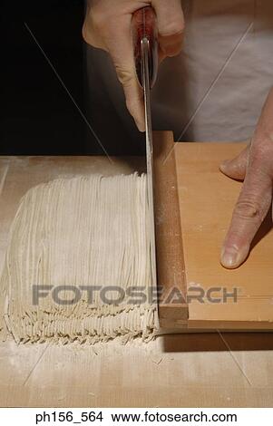 Mid section view of a person cutting noodles View Large Photo Image Picture - Mid section view of a person cutting noodles. Fotosearch