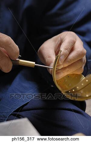 Stock Photo - Mid section view of a person inserting work tools into a metal bowl. Fotosearch