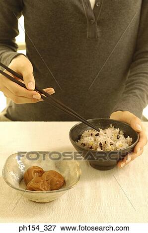Mid section view of a woman holding a bowl of rice View Large Photo Image Stock Photo - Mid section view of a woman holding a bowl of rice. Fotosearch
