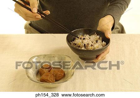 Mid section view of a woman holding a bowl of rice View Large Photo Image Stock Photo - Mid section view of a woman holding a bowl of rice. Fotosearch