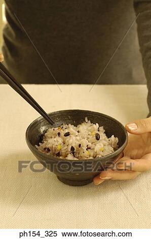 Mid section view of a woman holding a bowl of rice View Large Photo Image Stock Photography - Mid section view of a woman holding a bowl of rice. Fotosearch
