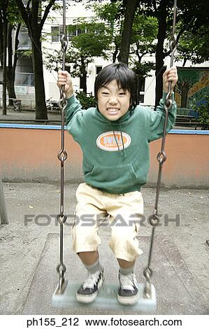 Portrait of a boy standing on a swing View Large Photo Image Stock Image - Portrait of a boy standing on a swing. Fotosearch