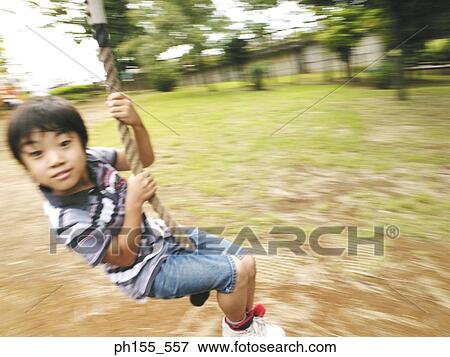 Portrait of a boy swinging on a rope View Large Photo Image Stock Photo - Portrait of a boy swinging on a rope. Fotosearch