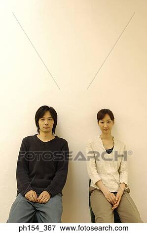 Portrait of a young couple sitting on stools View Large Photo Image Stock Photo - Portrait of a young couple sitting on stools. Fotosearch