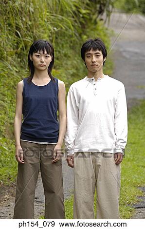 Portrait of a young couple standing in a garden View Large Photo Image Stock Photo - Portrait of a young couple standing in a garden. Fotosearch