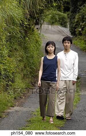 Portrait of a young couple walking in a garden View Large Photo Image Stock Image - Portrait of a young couple walking in a garden. Fotosearch