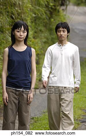 Portrait of a young couple walking in a garden View Large Photo Image Stock Image - Portrait of a young couple walking in a garden. Fotosearch