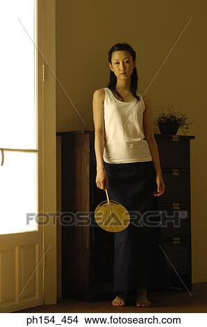 Portrait of a young woman holding a fan View Large Photo Image Picture - Portrait of a young woman holding a fan. Fotosearch