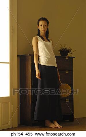 Portrait of a young woman holding a fan View Large Photo Image Stock Photography - Portrait of a young woman holding a fan. Fotosearch