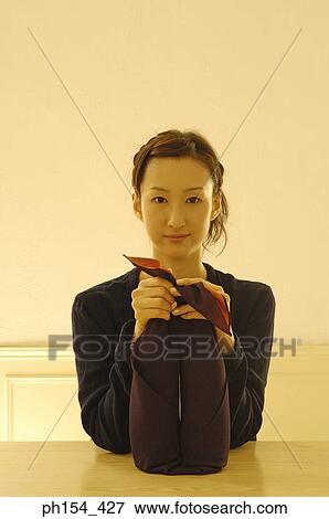 Portrait of a young woman holding two bottles wrapped in a cloth View Large Photo Image Stock Photo - Portrait of a young woman holding two bottles wrapped in a cloth. Fotosearch