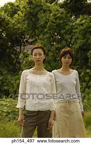 Stock Photo - Portrait of two young women standing together. Fotosearch