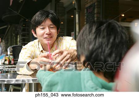 Rear view of a boy sitting with his father in a restaurant View Large Photo Image Stock Image - Rear view of a boy sitting with his father in a restaurant. Fotosearch