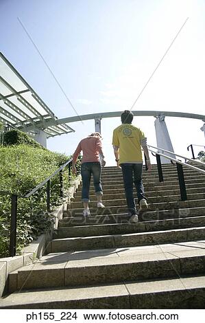Rear view of a man and a woman walking up steps View Large Photo Image Picture - Rear view of a man and a woman walking up steps. Fotosearch