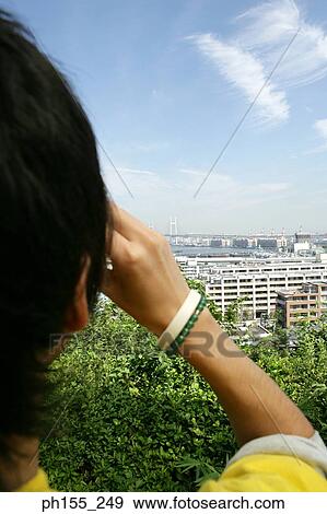 Rear view of a man looking at a view View Large Photo Image Stock Photo - Rear view of a man looking at a view. Fotosearch