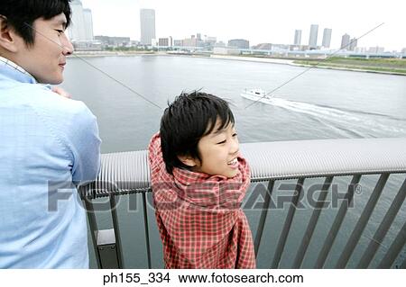 Rear view of a mid adult man and his son looking sideways View Large Photo Image Picture - Rear view of a mid adult man and his son looking sideways. Fotosearch
