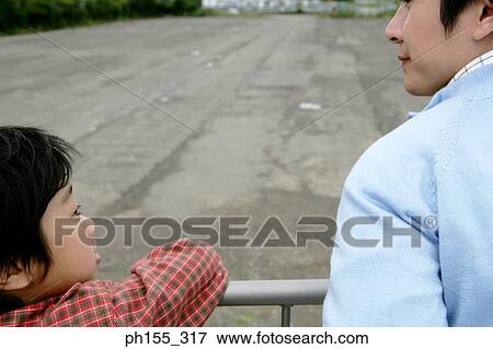 Stock Photo - Rear view of a mid adult man and his son. Fotosearch