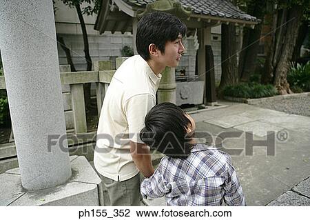 Rear view of a mid adult man holding his son's hand at a monastery View Large Photo Image Stock Image - Rear view of a mid adult man holding his son's hand at a monastery. Fotosearch
