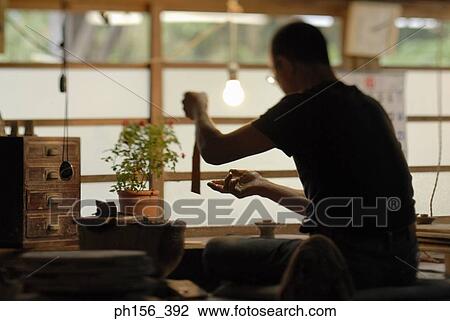 Rear view of a potter working View Large Photo Image Stock Image - Rear view of a potter working. Fotosearch