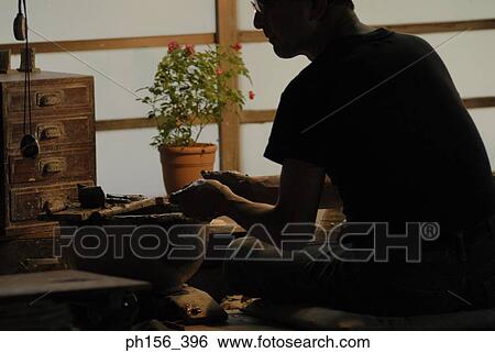 Rear view of a potter working View Large Photo Image Stock Photograph - Rear view of a potter working. Fotosearch