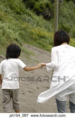 Rear view of a woman and her son walking View Large Photo Image Stock Photo - Rear view of a woman and her son walking. Fotosearch
