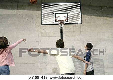 Rear view of two young men and a young woman playing basketball View Large Photo Image Stock Photo - Rear view of two young men and a young woman playing basketball. Fotosearch