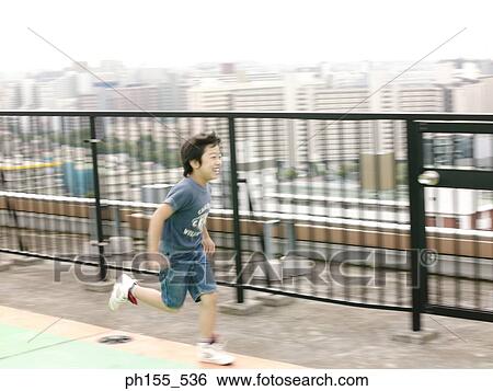 Side profile of a boy running near a railing View Large Photo Image Stock Photograph - Side profile of a boy running near a railing. Fotosearch