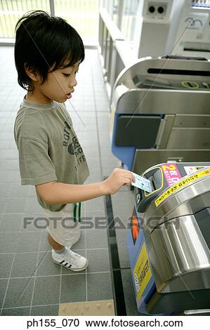 Side profile of a boy using a machine at a subway station View Large Photo Image Stock Image - Side profile of a boy using a machine at a subway station. Fotosearch