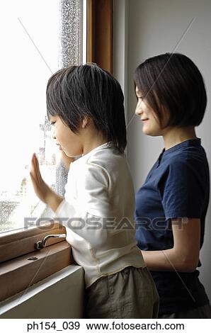 Side profile of a girl and her mother looking through a window View Large Photo Image Stock Photo - Side profile of a girl and her mother looking through a window. Fotosearch