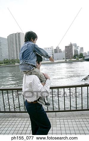 Side profile of a man carrying his son on his shoulders View Large Photo Image Stock Photo - Side profile of a man carrying his son on his shoulders. Fotosearch