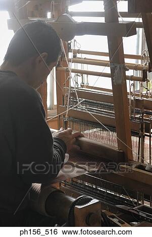 Stock Photograph - Side profile of a mature man working on a loom. Fotosearch