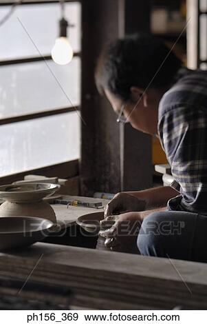 Stock Photo - Side profile of a potter making a pot. Fotosearch
