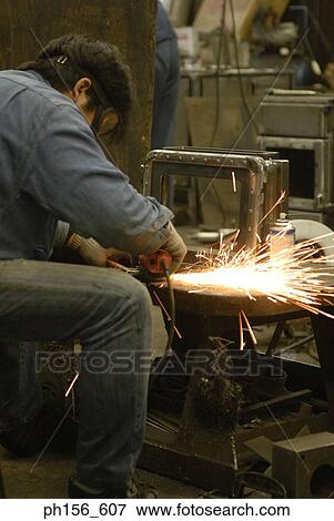Stock Photo - Side profile of a welder welding in a workshop. Fotosearch