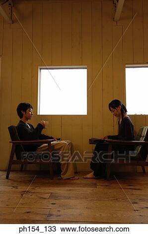 Side profile of a young couple sitting near windows View Large Photo Image Stock Image - Side profile of a young couple sitting near windows. Fotosearch