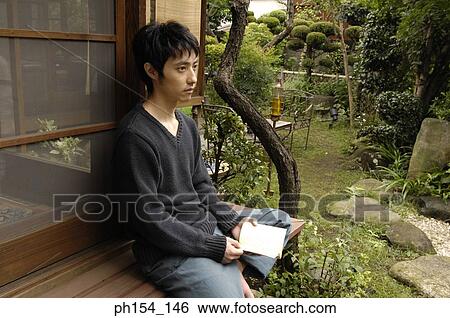 Side profile of a young man holding a book and thinking View Large Photo Image Stock Photograph - Side profile of a young man holding a book and thinking. Fotosearch