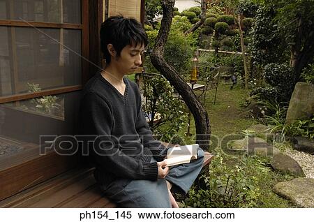 Side profile of a young man reading a book View Large Photo Image Stock Photography - Side profile of a young man reading a book. Fotosearch