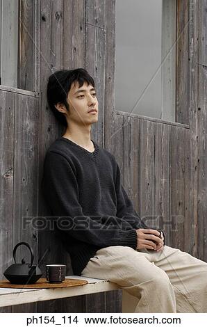 Side profile of a young man sitting on a bench View Large Photo Image Picture - Side profile of a young man sitting on a bench. Fotosearch
