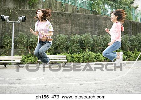 Side profile of two young women jumping on a jump rope View Large Photo Image Stock Photo - Side profile of two young women jumping on a jump rope. Fotosearch