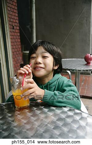 Teenage boy holding a glass of juice View Large Photo Image Picture - Teenage boy holding a glass of juice. Fotosearch