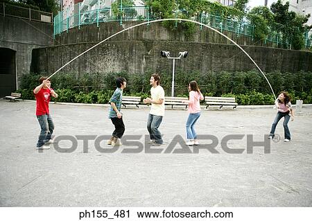 Three friends jumping on a jump rope View Large Photo Image Stock Image - Three friends jumping on a jump rope. Fotosearch