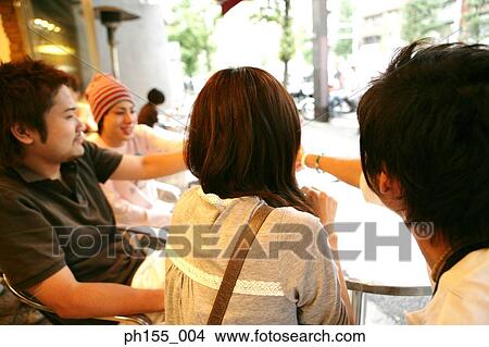Three young men and a young woman sitting in a restaurant View Large Photo Image Picture - Three young men and a young woman sitting in a restaurant. Fotosearch