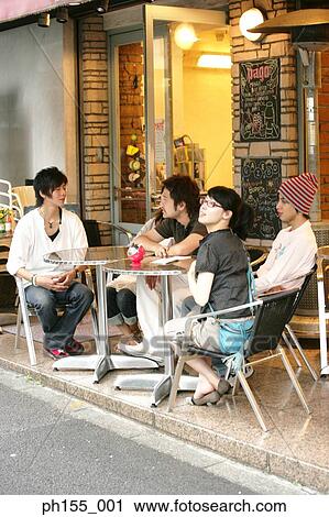 Three young men and a young woman sitting outside a restaurant View Large Photo Image Stock Image - Three young men and a young woman sitting outside a restaurant. Fotosearch