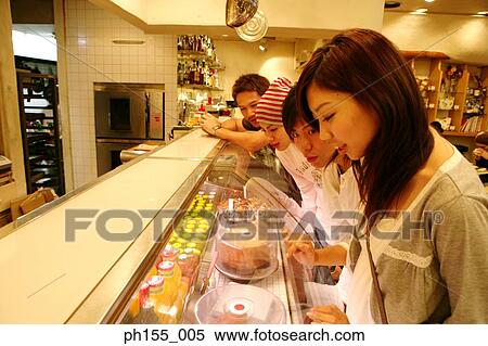 Three young men and a young woman standing together in a restaurant View Large Photo Image Stock Photography - Three young men and a young woman standing together in a restaurant. Fotosearch