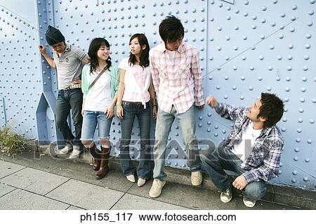 Three young men and two young women in front of a riveted metallic structure View Large Photo Image Stock Photo - Three young men and two young women in front of a riveted metallic structure. Fotosearch