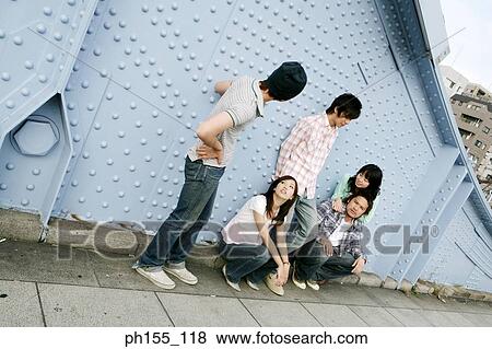 Three young men and two young women in front of a riveted metallic structure View Large Photo Image Stock Photo - Three young men and two young women in front of a riveted metallic structure. Fotosearch